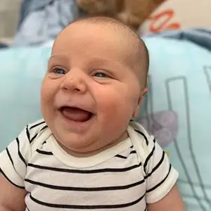 Close up picture of an infant boy with a very big smile.